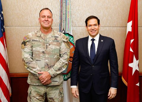 General Michael Kurilla in Army uniform stands beside Secretary of State Marco Rubio in front of a U.S. Central Command flag and seal at CENTCOM headquarters