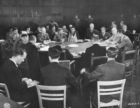 Foreign secretaries meeting around a large table at Cecilienhof Palace during the Potsdam Conference, 1945, with British and American flags on the table and officers standing behind