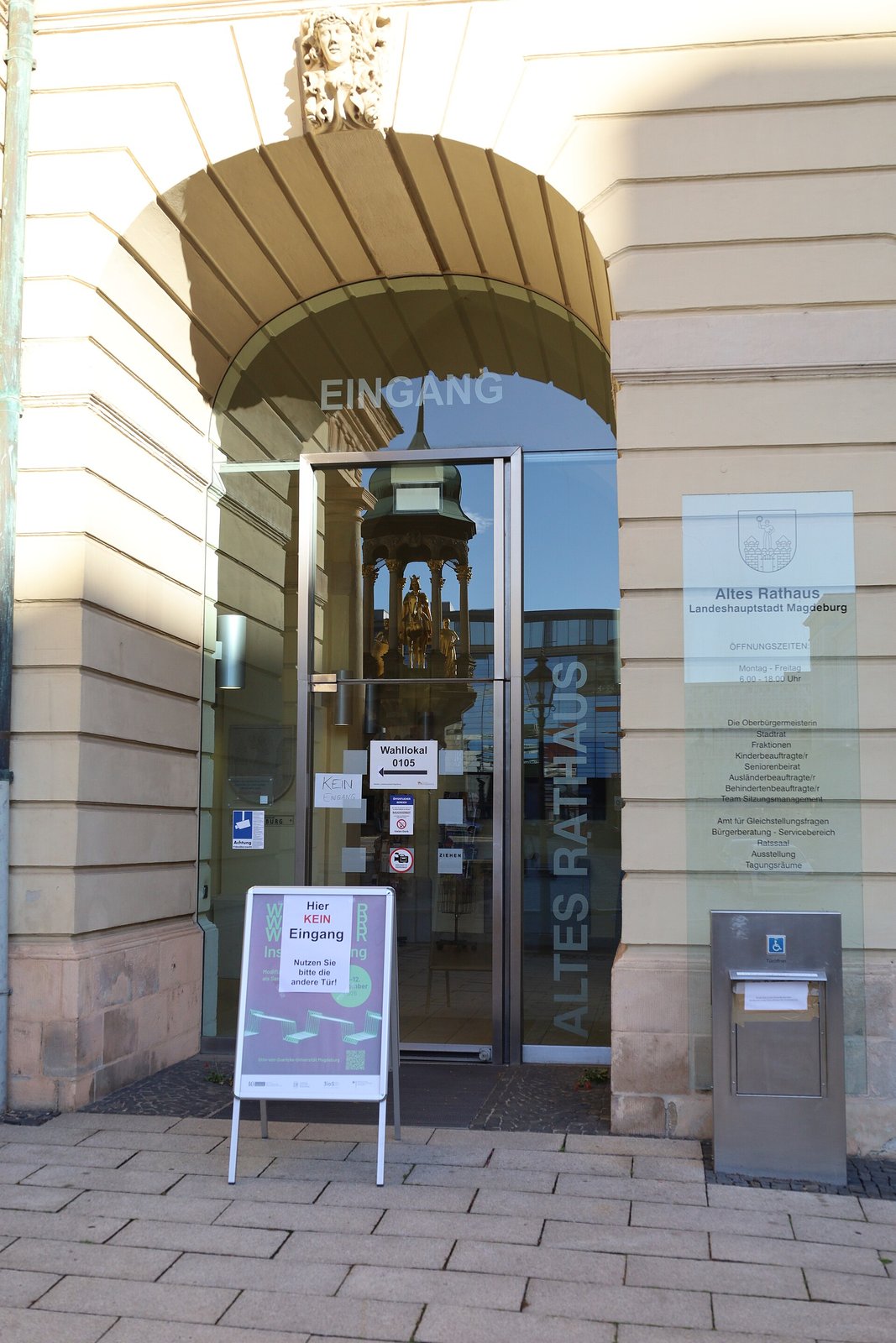 Entrance of the Altes Rathaus in Magdeburg with a sign reading Wahllokal 0105 (polling station) on the glass door