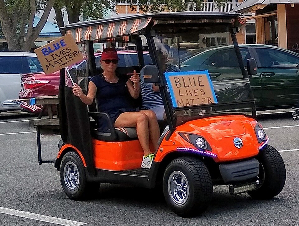 Golf cart with two "Blue Lives Matter" signs at a rally, 2020
