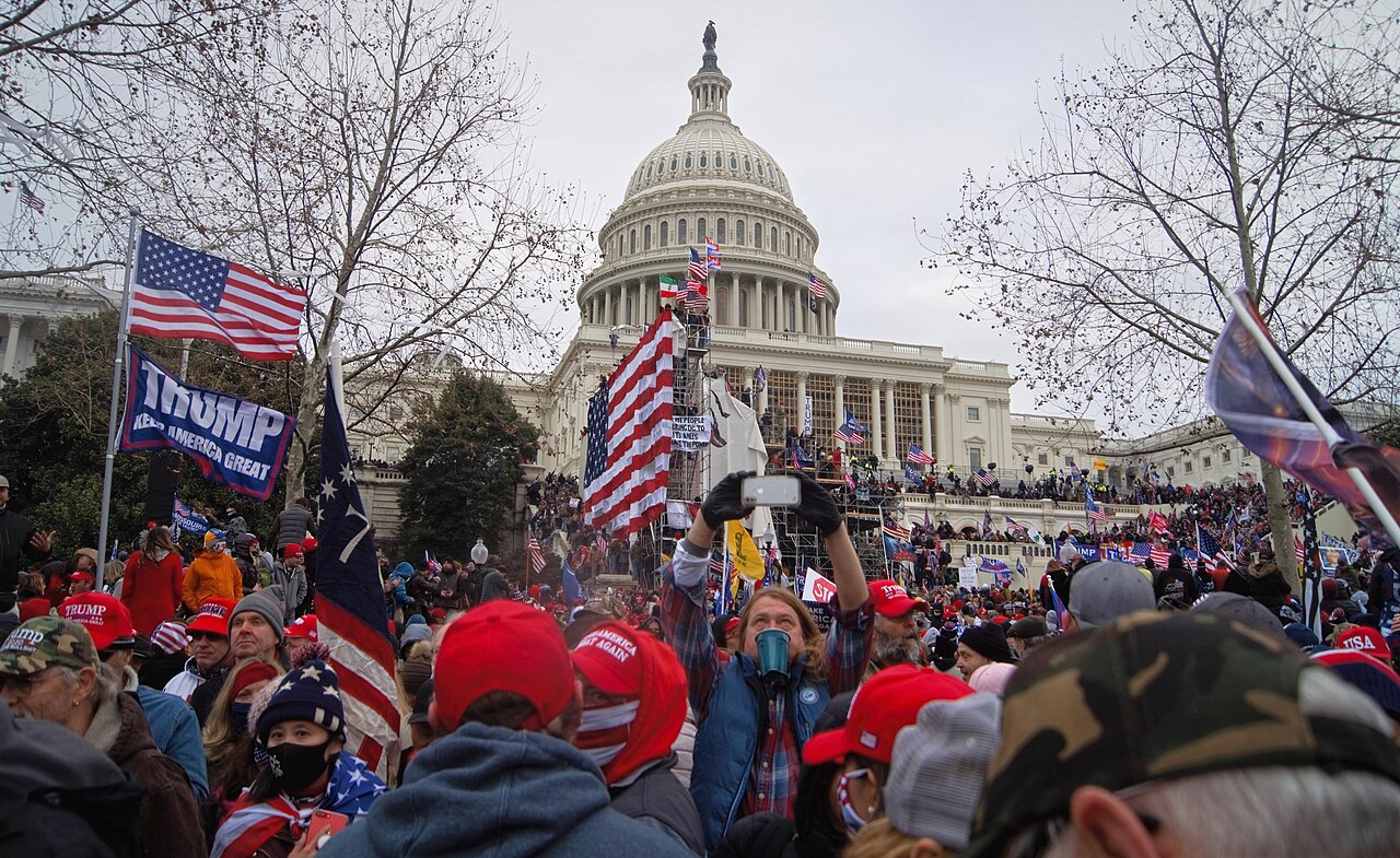 Crowd in red caps with a "Trump Keep America Great" banner on the Capitol grounds, 6 January 2021