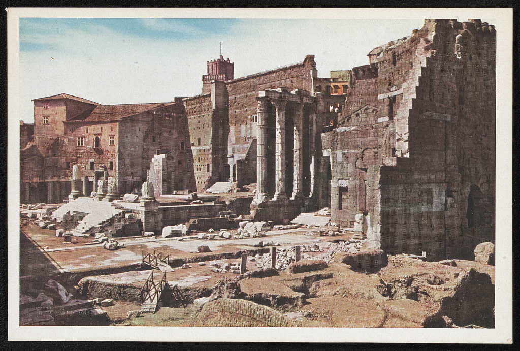 Photograph of the ruined Forum of Augustus in Rome, with three standing Corinthian columns of the temple of Mars Ultor against a high stone wall