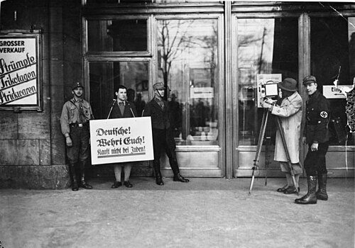 SA men posting a boycott sign outside a department store door, Berlin, 1 April 1933