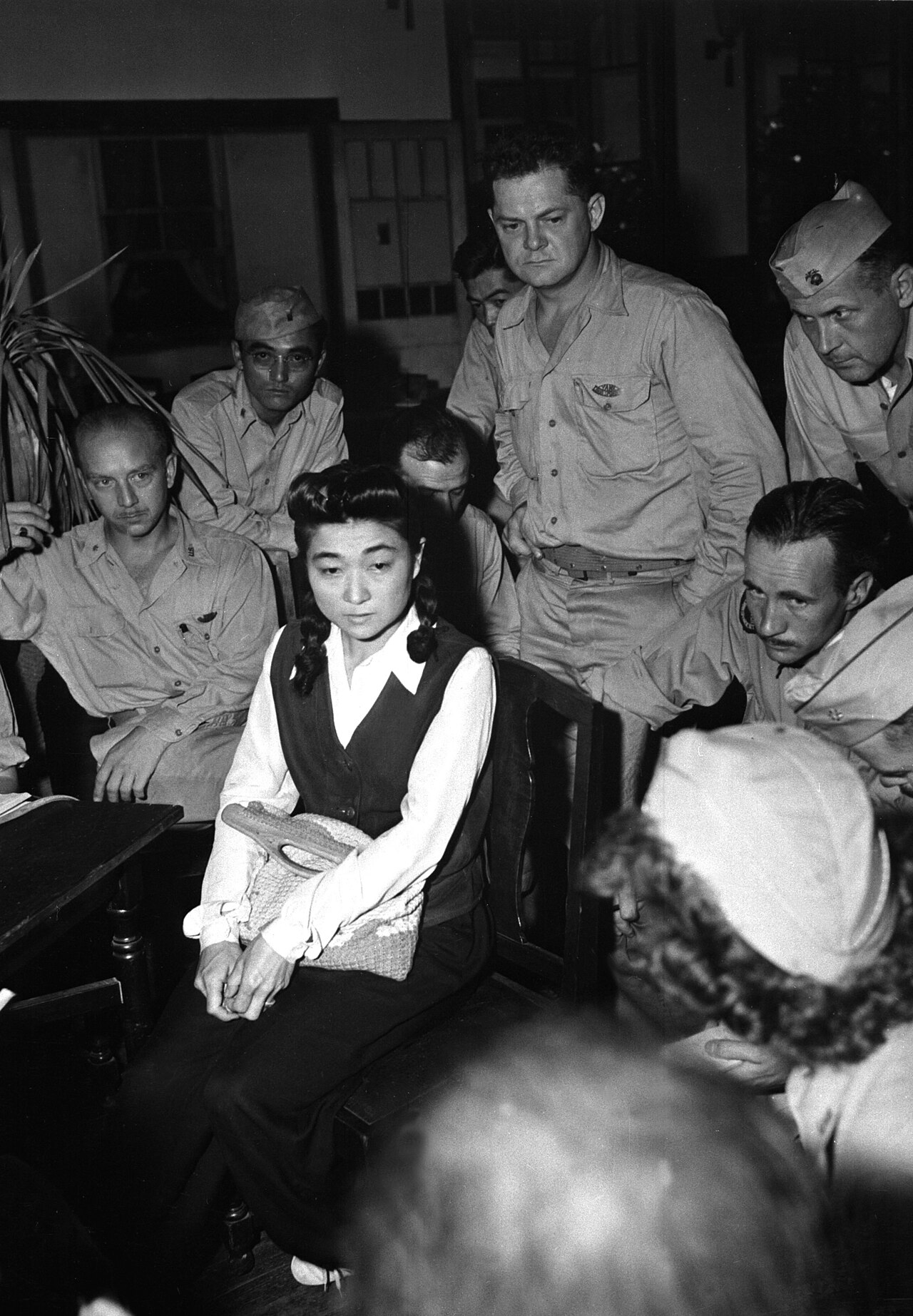 Iva Toguri at a microphone with U.S. correspondents, September 1945
