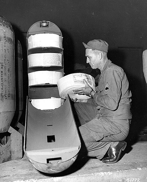 A U.S. Army sergeant loads rolls of leaflets into a bomb casing in Yokohama