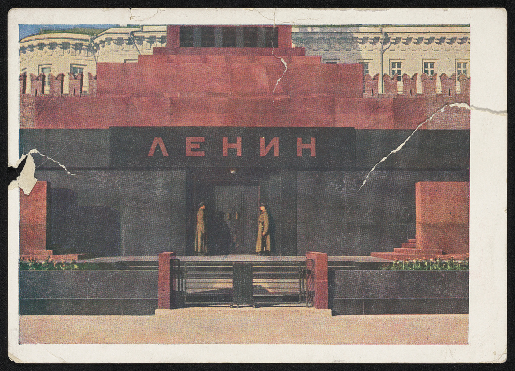 A 1931 postcard photograph of the newly completed granite Lenin Mausoleum on Red Square, Moscow, with two guards standing at the entrance below the lettering "ЛЕНИН" and the Kremlin wall behind it