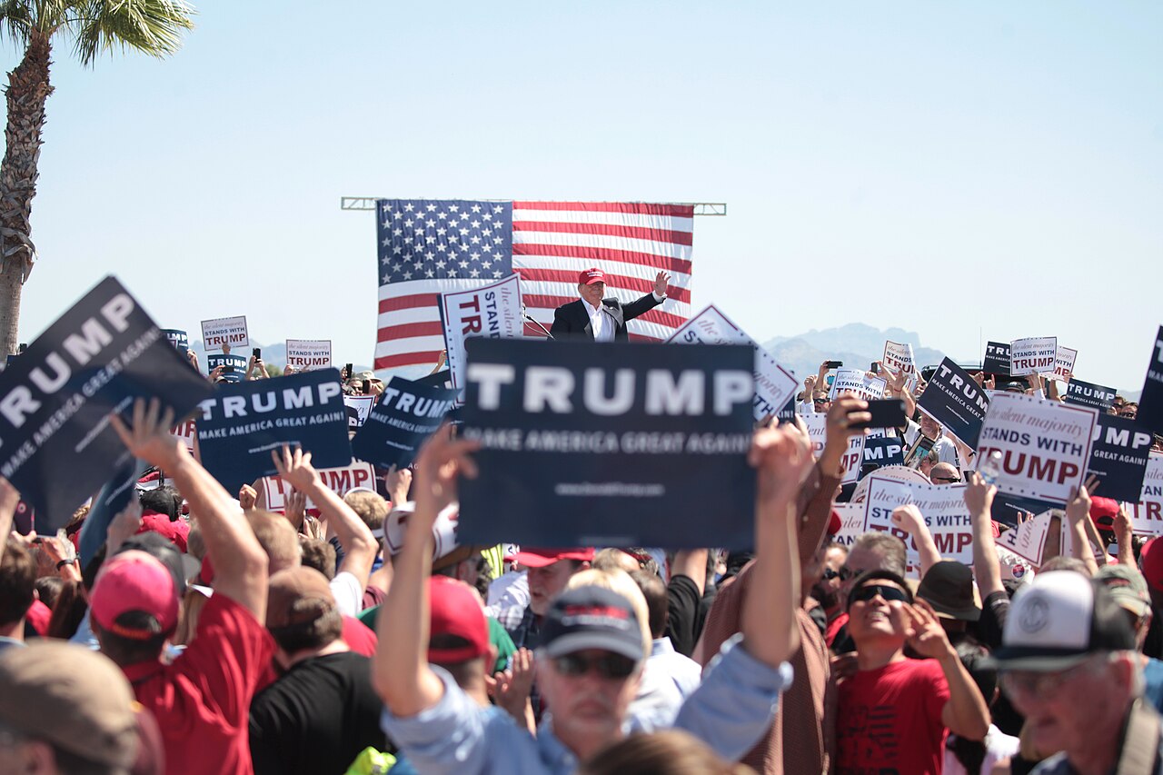 Donald Trump speaks to supporters in red caps holding "Make America Great Again" signs, Fountain Hills, Arizona, March 2016