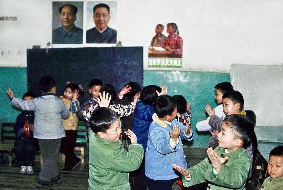 Children dancing in a Shanghai kindergarten in 1978 beneath portraits of Mao Zedong and Hua Guofeng and a study poster