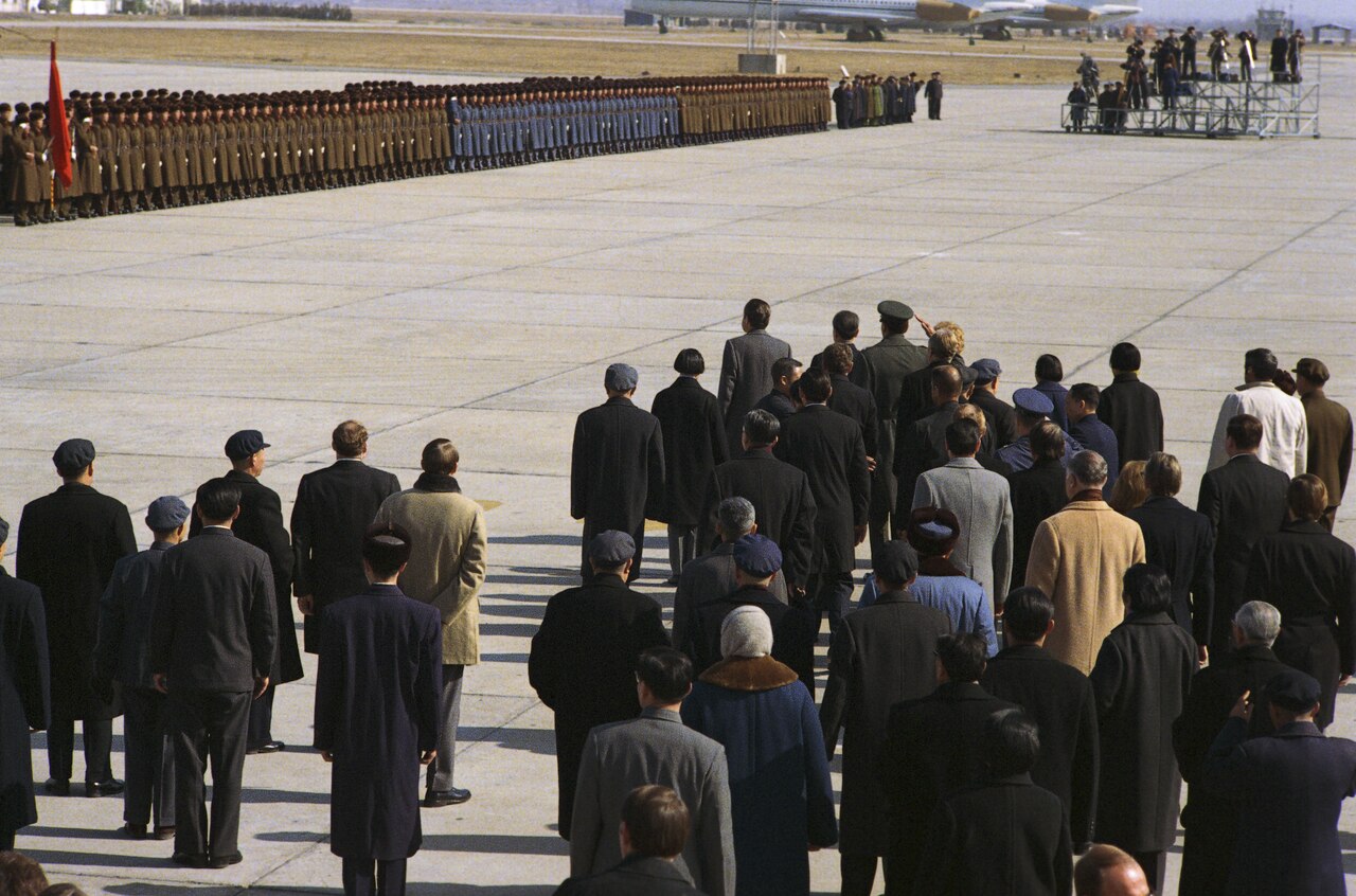 Rows of Chinese service personnel drawn up as an honor guard on the tarmac at Capital Airport, Peking, in 1972, with officials in the foreground