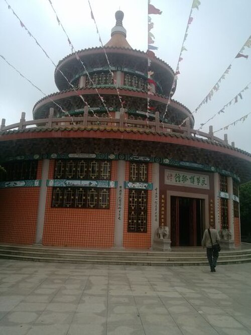 Exterior of the multi-tiered round Cultural Revolution Museum building in Shantou, Guangdong, with strings of flags overhead