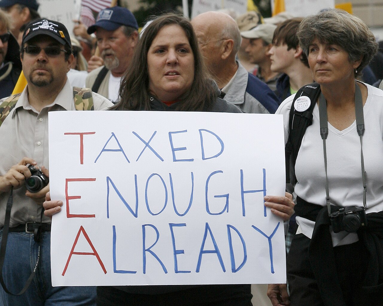 A marcher holds a hand-lettered sign reading "Taxed Enough Already", with the initials T, E and A in red, at the Taxpayer March on Washington