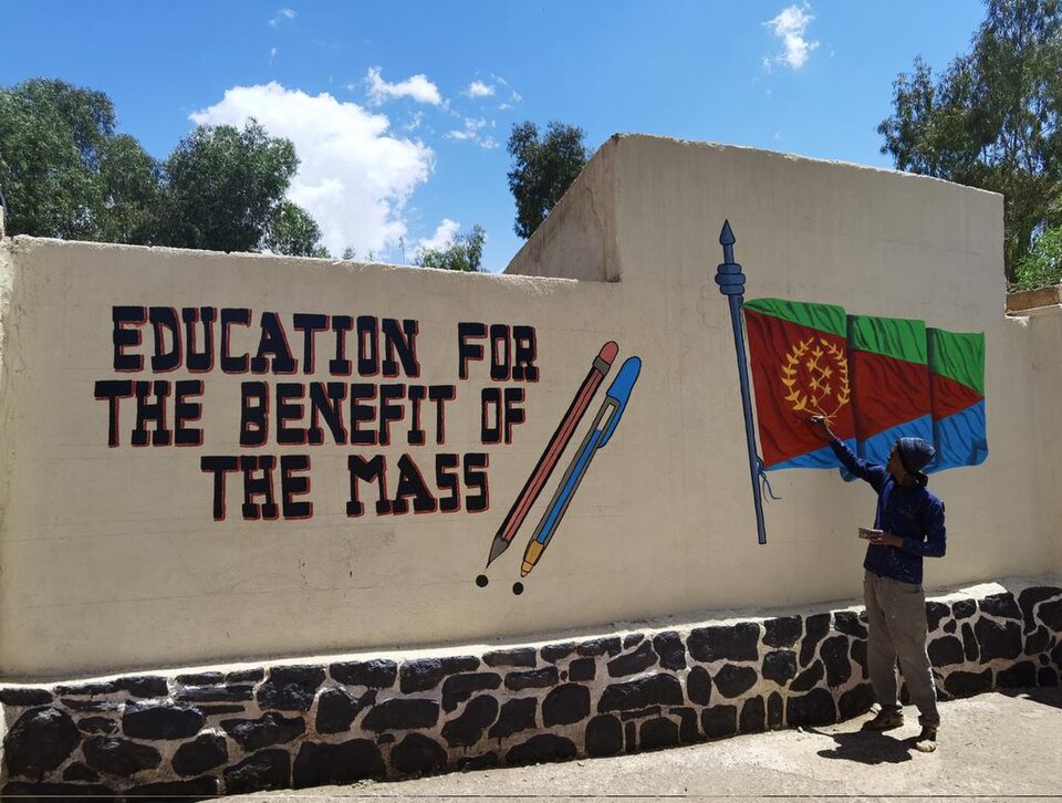 Education for the benefit of the mass: painted wall slogan with Eritrean flag, Asmara