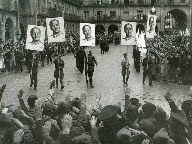 Franco portraits carried through Salamanca's Plaza Mayor to celebrate the fall of Gijón, 1937