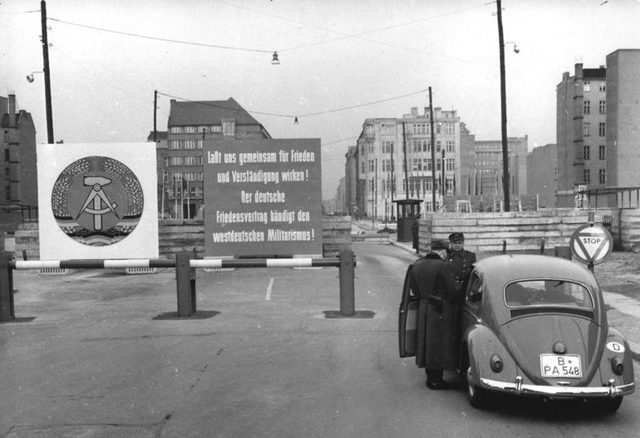 "Der deutsche Friedensvertrag bändigt den westdeutschen Militarismus!": sign at the Friedrichstraße checkpoint, Berlin