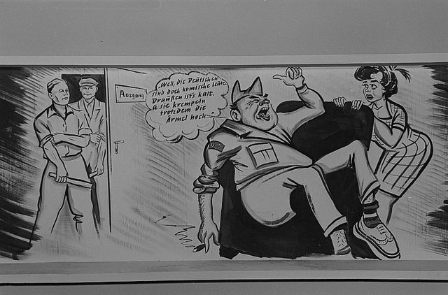 Caricature panel of a US soldier with workers at an exit door, Rössing photograph