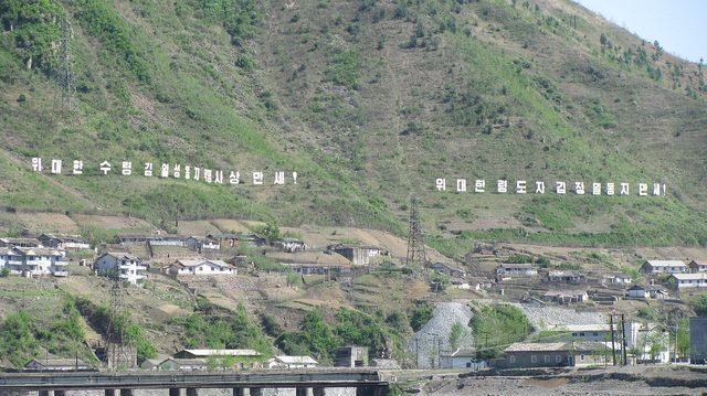 Hillside slogans for Kim Il-sung and Kim Jong-il, across the Yalu from Supung (photographed 2009)