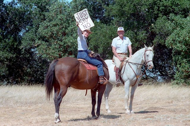Nancy Reagan holds up a 'Just Say No' sign for press photographers