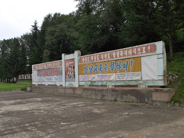 "강성대국을 향하여!": roadside slogan board (photographed 2011)