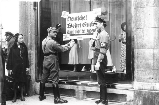 'Deutsche! Wehrt Euch! Kauft nicht bei Juden!' (Germans! Defend yourselves! Don't buy from Jews!): SA and SS men post a boycott sign, Berlin
