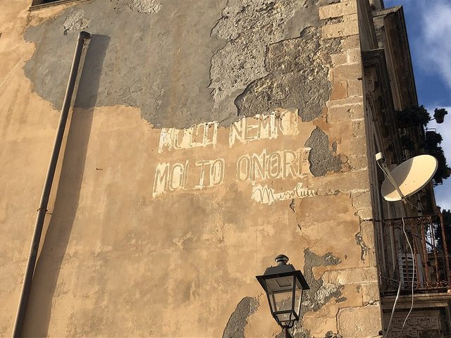 Faded wall slogan 'Molti nemici molto onore' signed Mussolini, Ortygia (Syracuse)