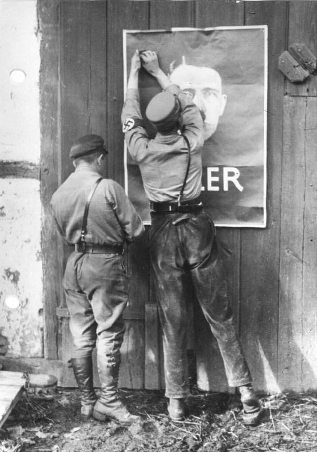 Zwei SA-Männer bringen ein Hitler-Plakat an (Mecklenburg)