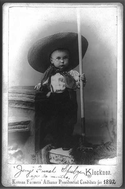 Cabinet-card photograph of a toddler in farmer's clothes holding a pitchfork, captioned Kansas Farmers' Alliance Presidential Candidate for 1892