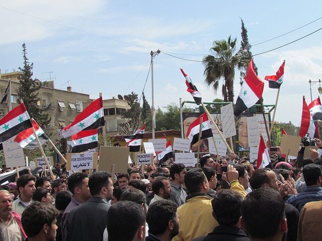 Protesters with 'Peaceful' signs and Syrian flags, Douma (near Damascus, 8 April 2011)