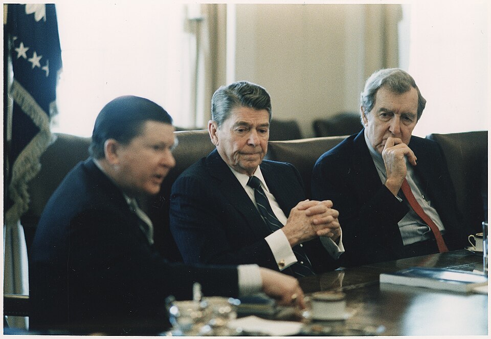 President Reagan seated between John Tower and Edmund Muskie in the Cabinet Room