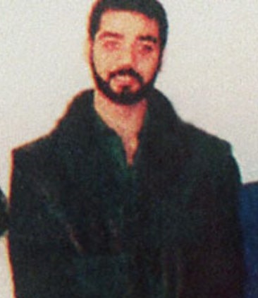 Uday Hussein in a dark coat in an undated frame from Iraqi state television