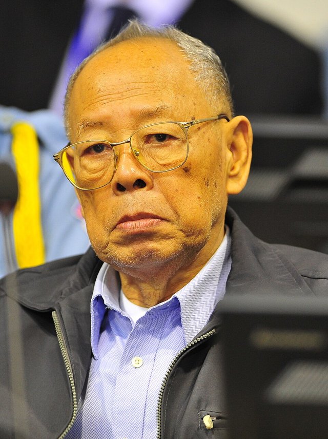 Ieng Sary, an elderly man in glasses and a dark jacket over a blue shirt, seated in a courtroom in 2011