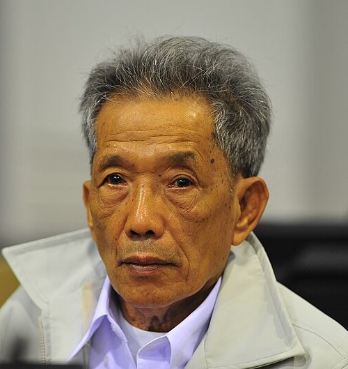 Kaing Guek Eav, known as Duch, an elderly man with grey hair in a pale jacket, seated in a courtroom in 2011