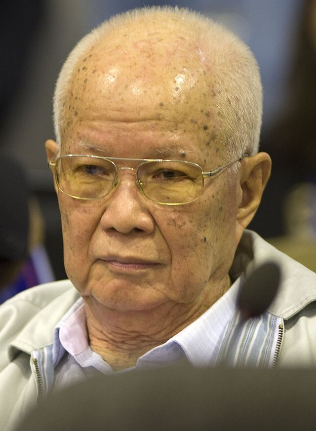 Khieu Samphan, an elderly bald man in glasses and a light jacket, seen in a courtroom in 2014