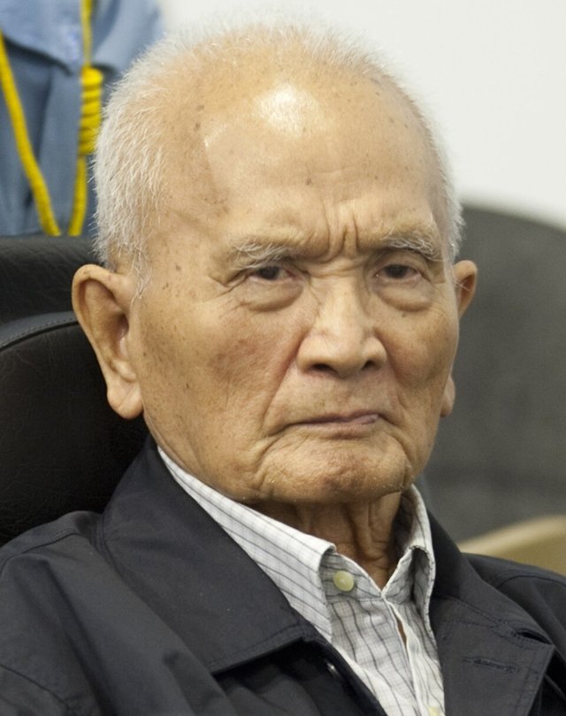 Nuon Chea, an elderly man with white hair, seated in a courtroom in 2013