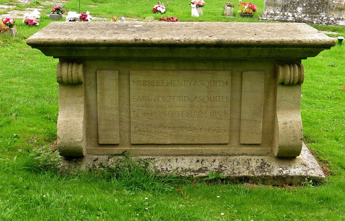 A stone chest tomb on grass, its front panel carved HERBERT HENRY ASQUITH, EARL OF OXFORD & ASQUITH, Born 12 September 1852, Died 15 February 1928