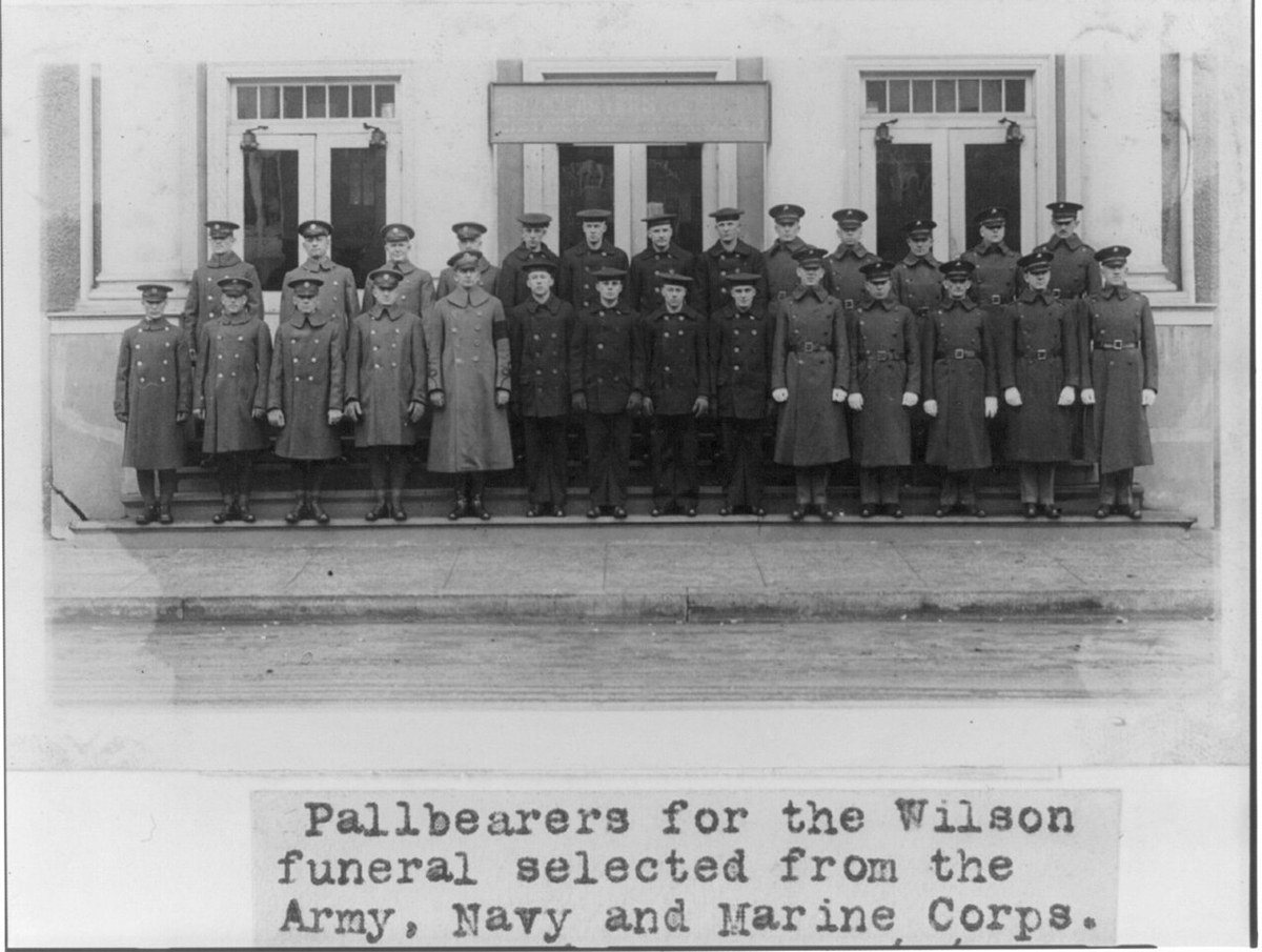 Twenty-seven uniformed men in two rows on the steps of a building, with a typed caption below reading Pallbearers for the Wilson funeral selected from the Army, Navy and Marine Corps