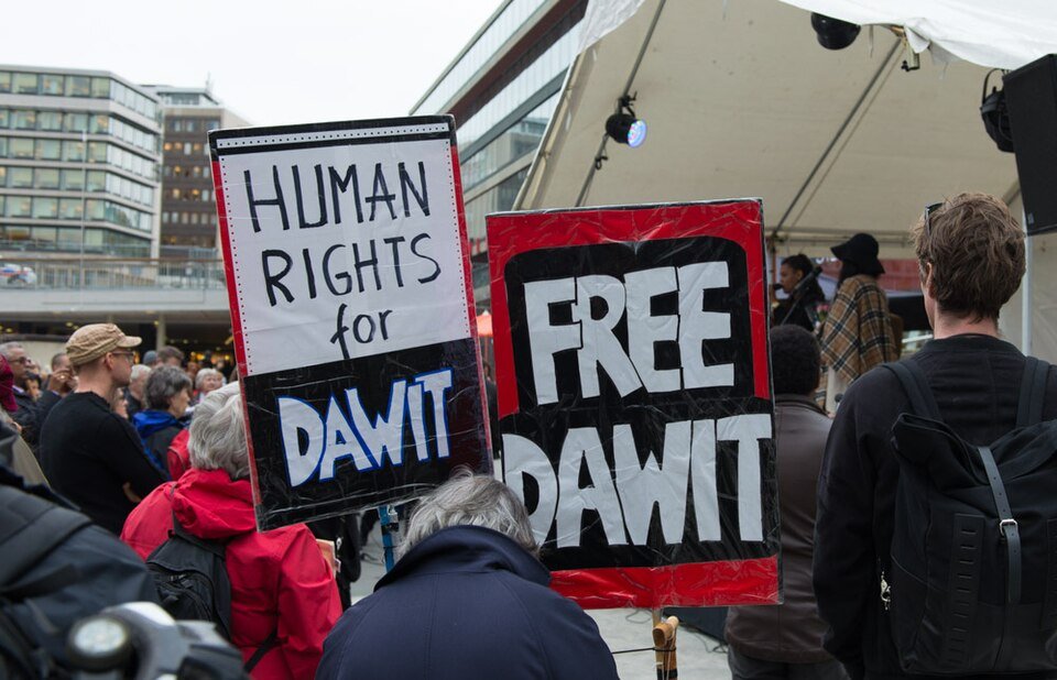 Two hand-lettered protest signs reading 'Human Rights for Dawit' and 'Free Dawit' at an outdoor demonstration.