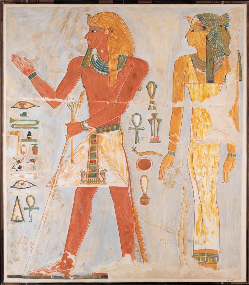 A painted copy of a relief: a king in a striped headcloth holding a staff and raising one hand, facing a woman in a long dress, beside columns of hieroglyphs and life signs.